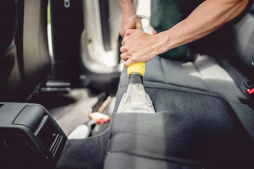 Car detailing and car care concept – Professional using steam vacuum for draining stains Oil Change & Tuneup Burlington, WI