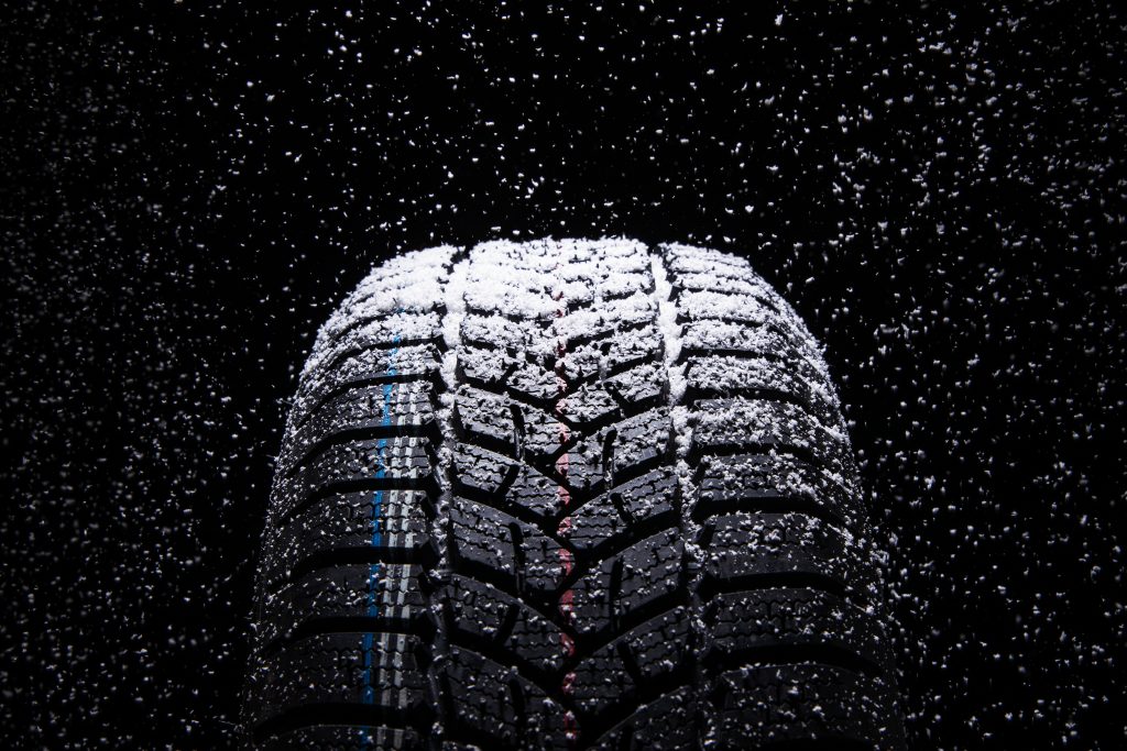Winter Car tires with snow on black background